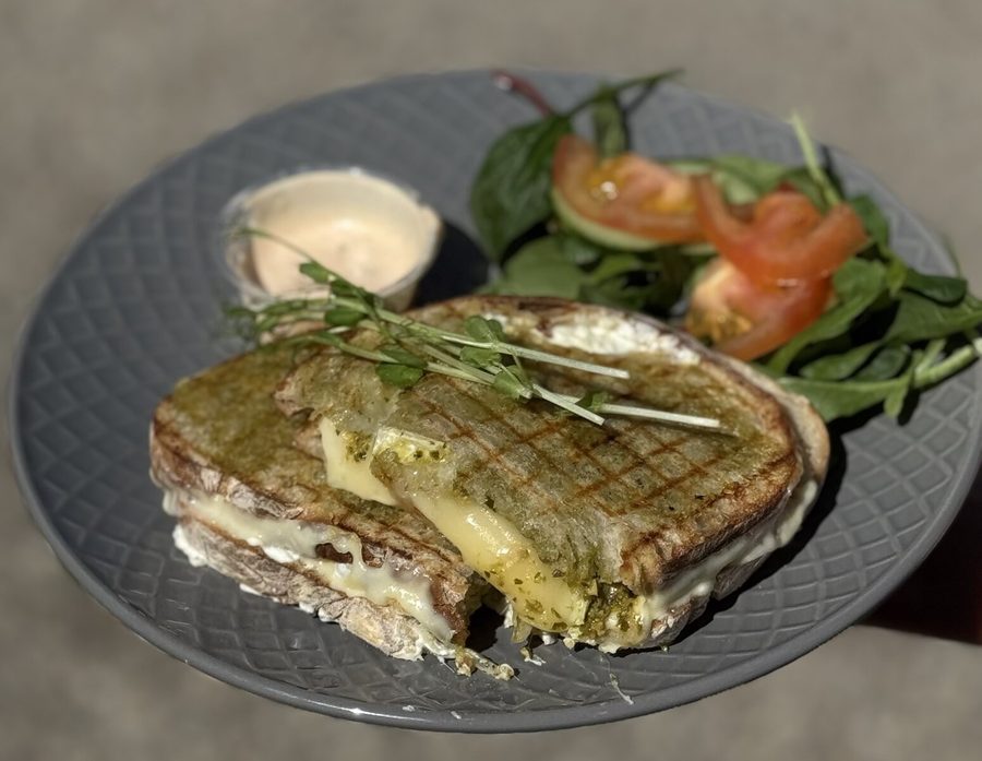 Grillad macka på surdegsbröd med smält ost, serverad med tomat, sallad och dressing
